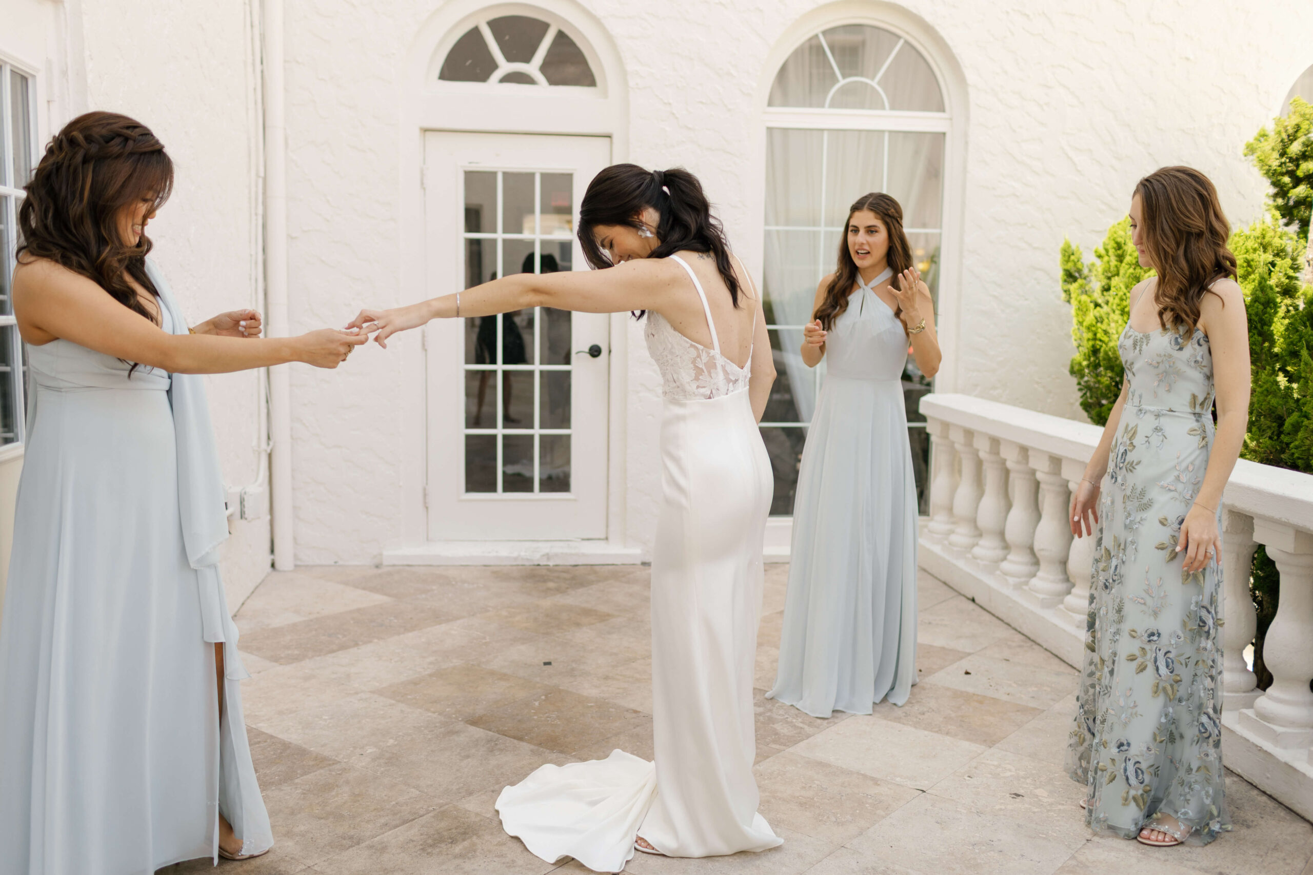 three women look at bride in wedding dress at casa marina jacksonville wedding