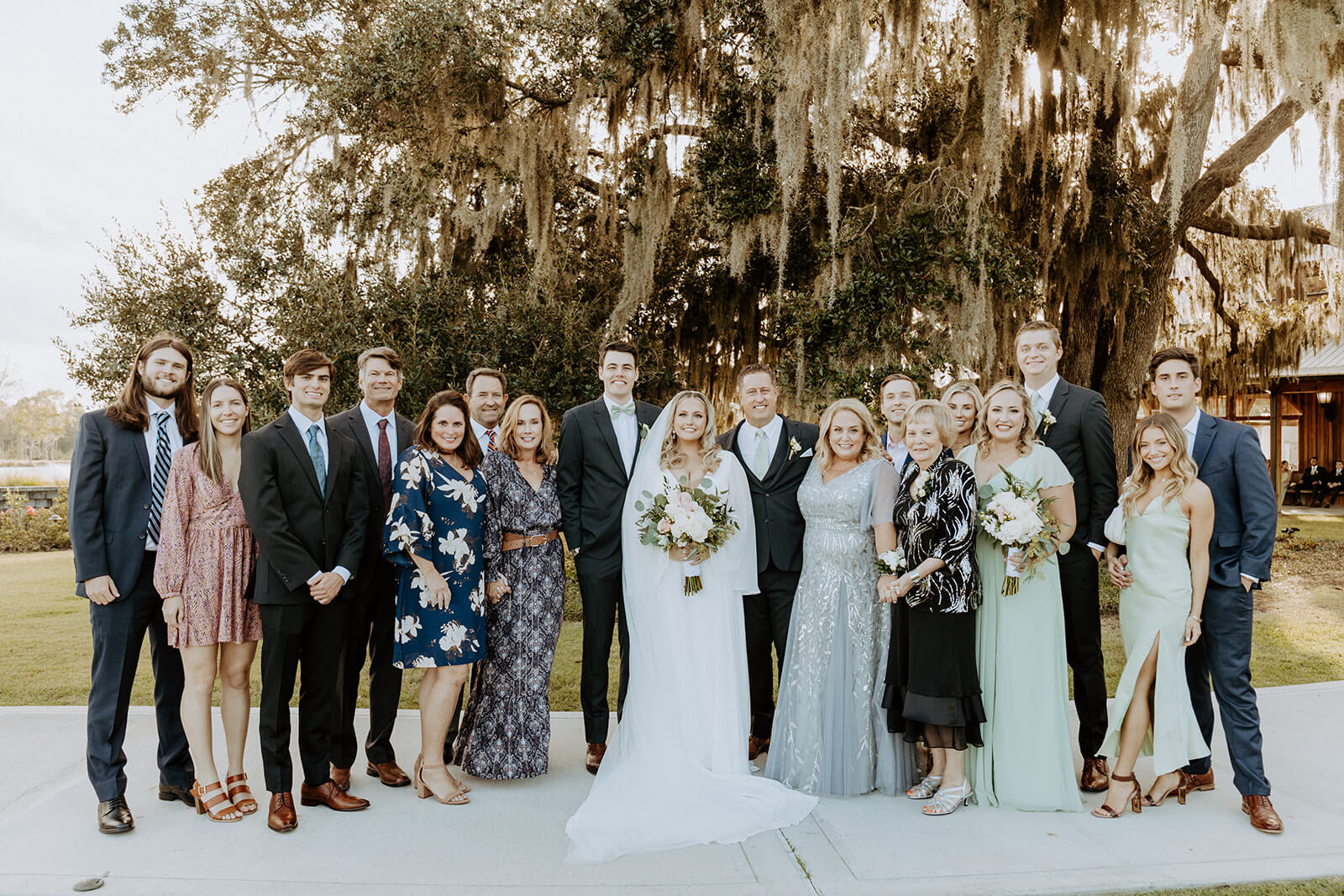 bride and groom stand with family