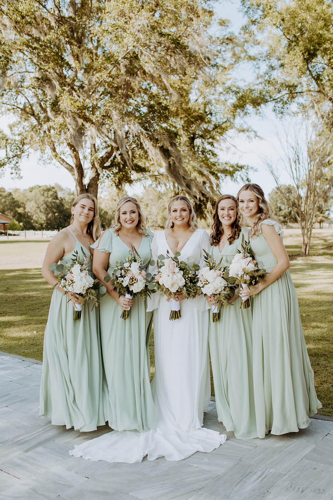 bride surrounded by women with flowers