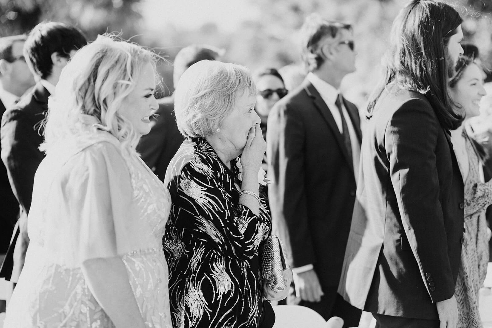 women cries while watching granddaughter walk down aisle