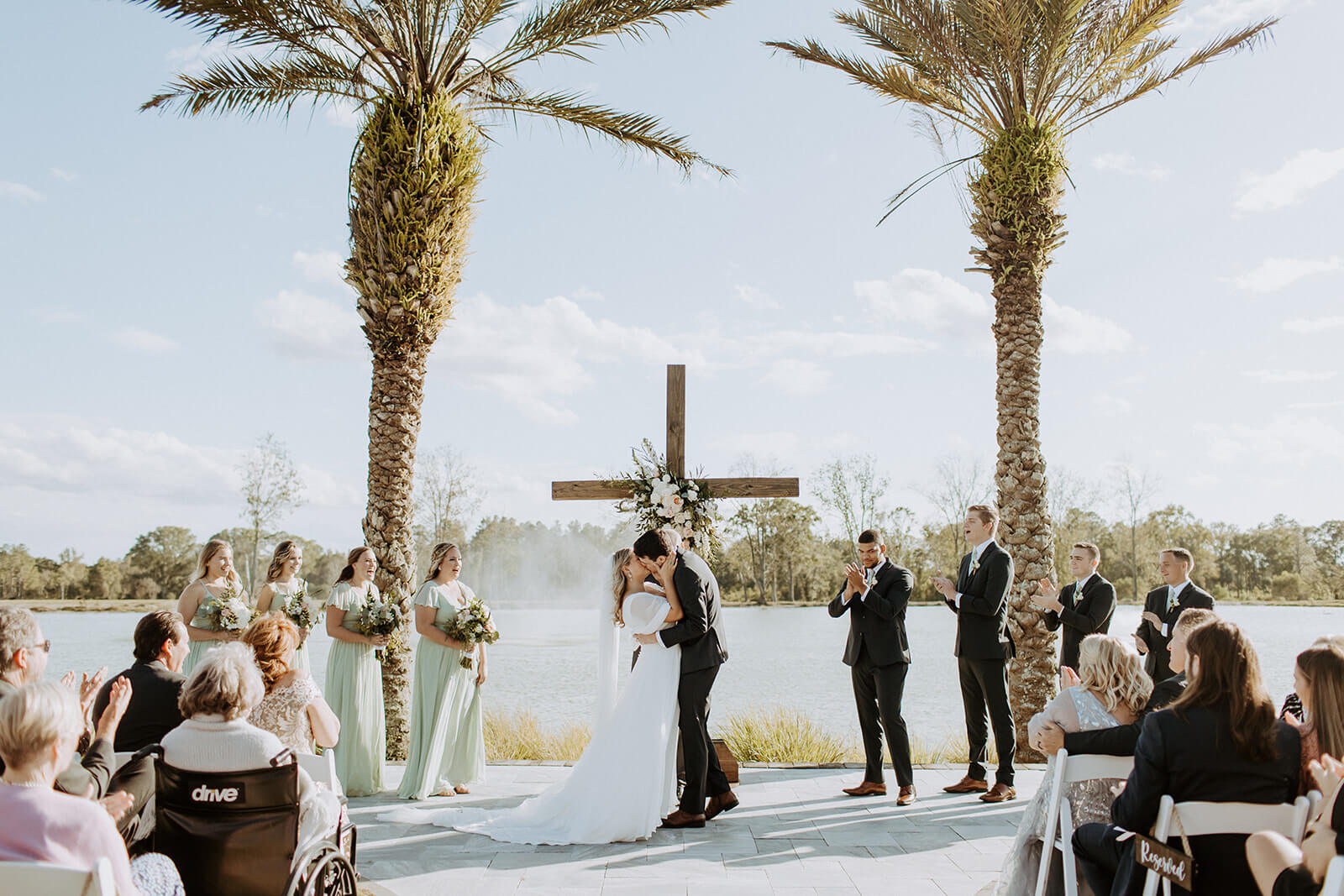 bride and groom kiss at wedding alter