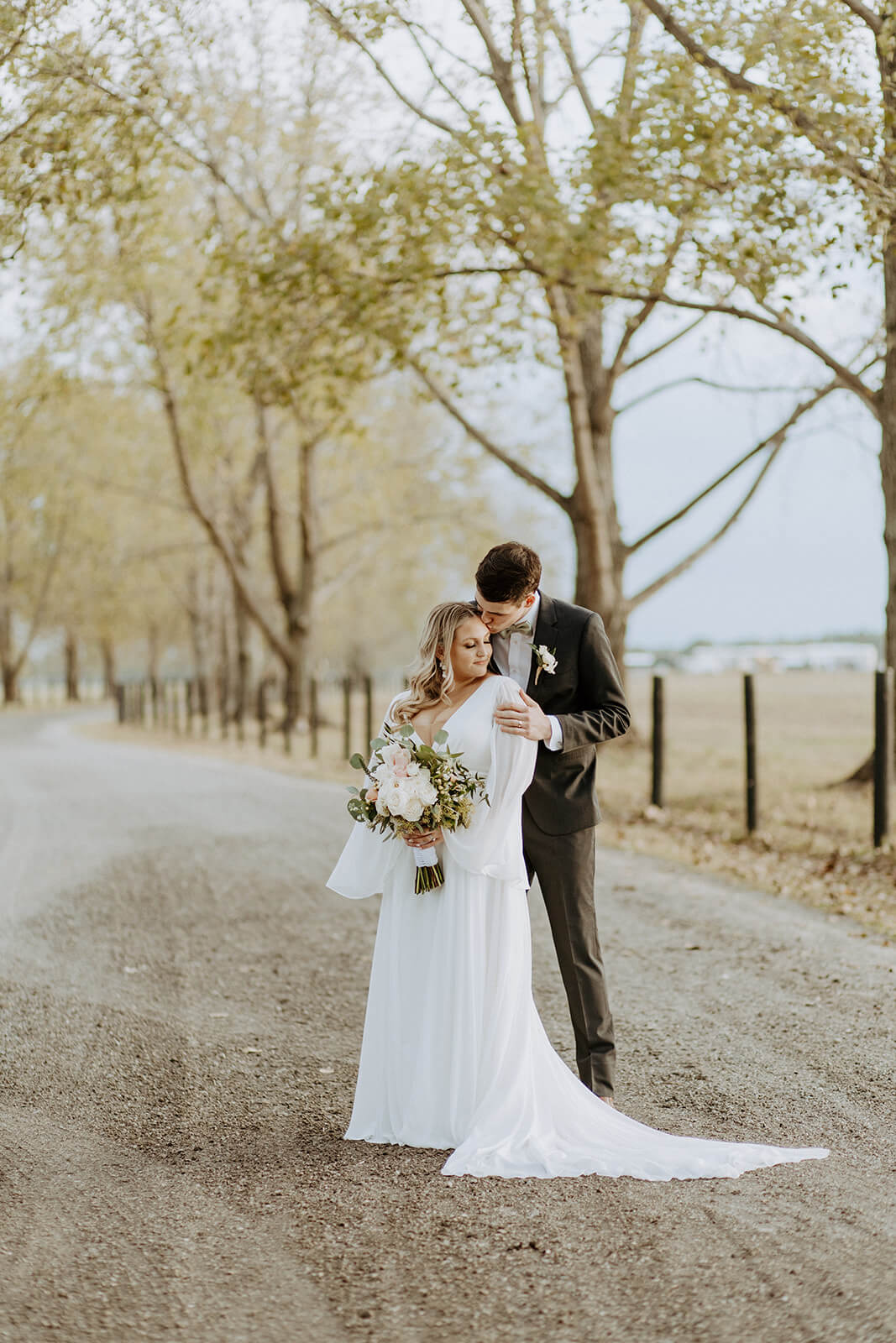 bride and groom embrace on dirt road in jacksonville florida