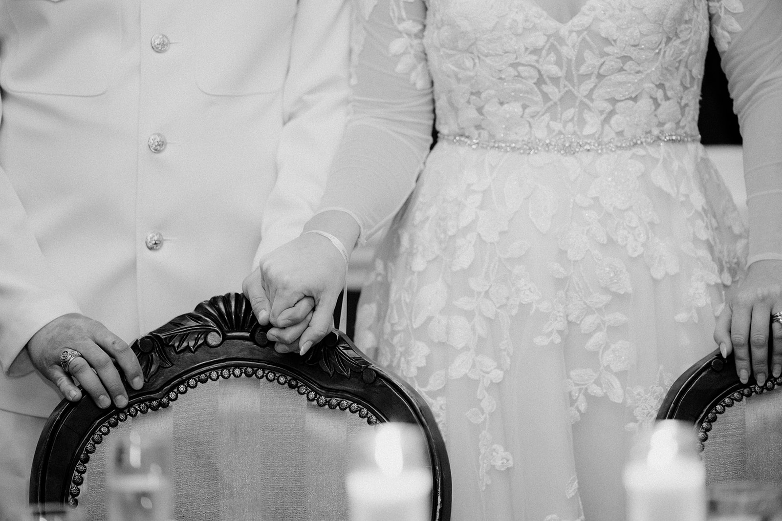 close up image of bride and groom holding hands