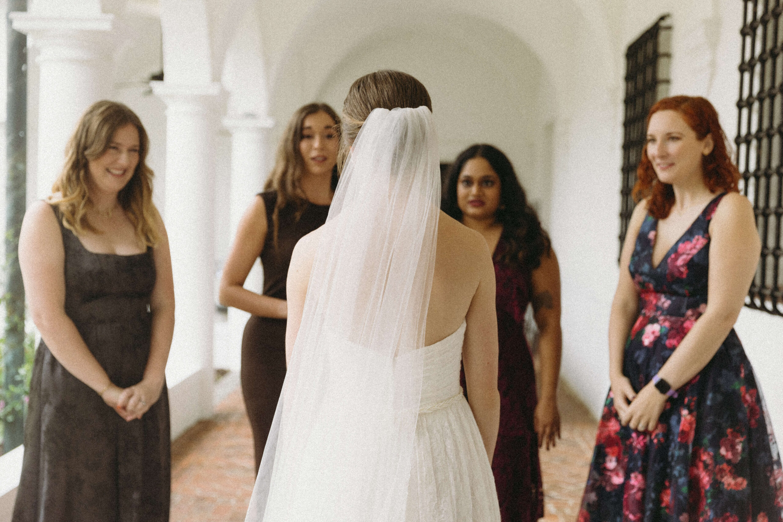 back of bride standing in front of four women