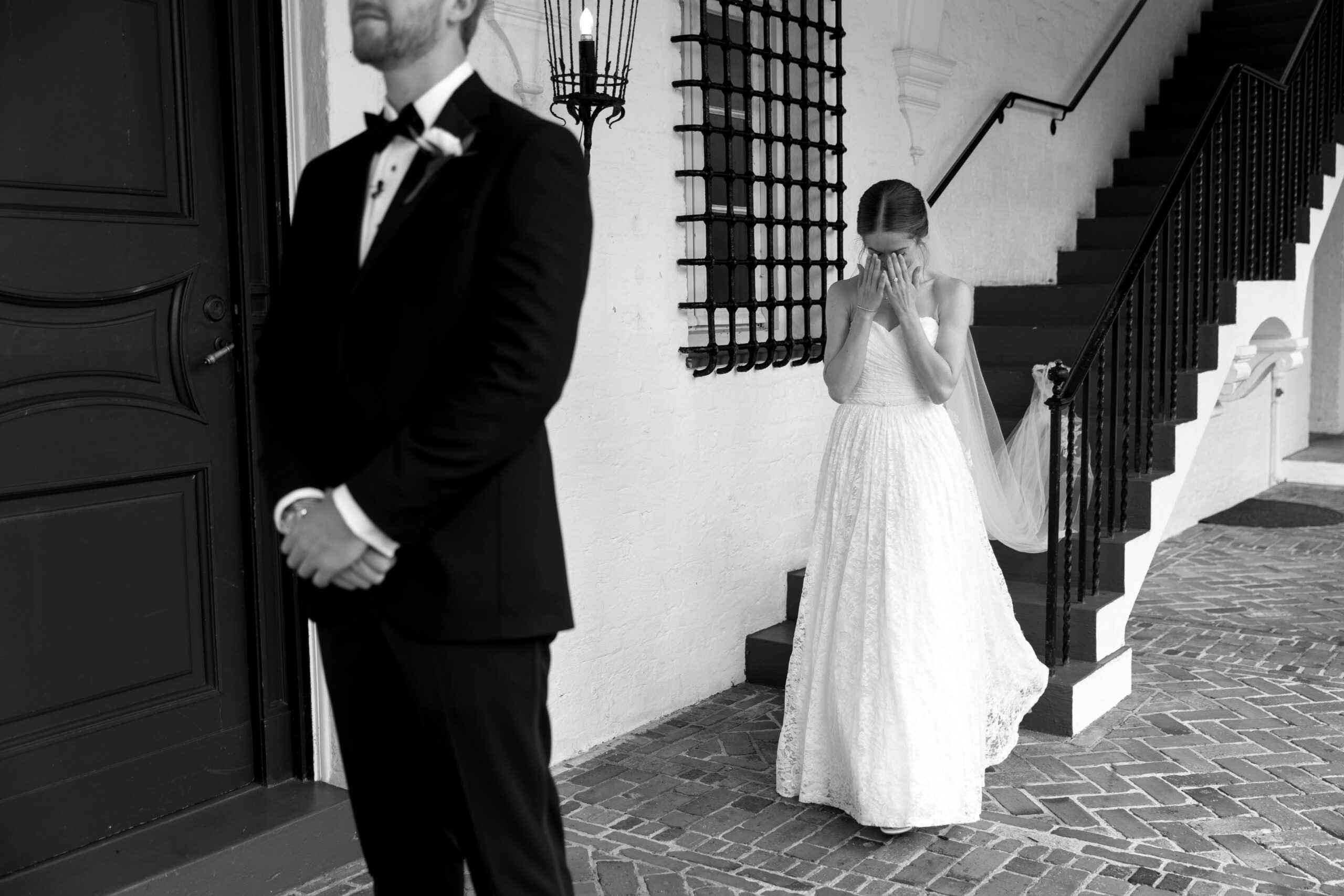 bride covering her eyes behind groom
