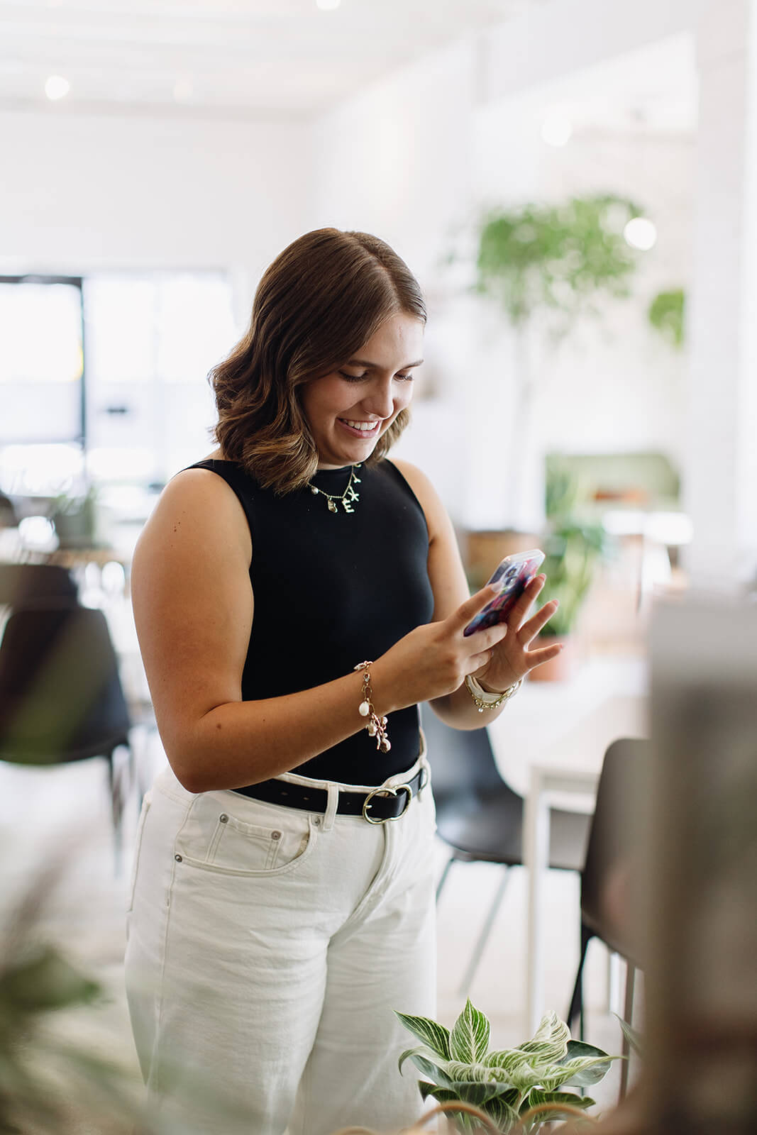 woman holding and smiling at phone