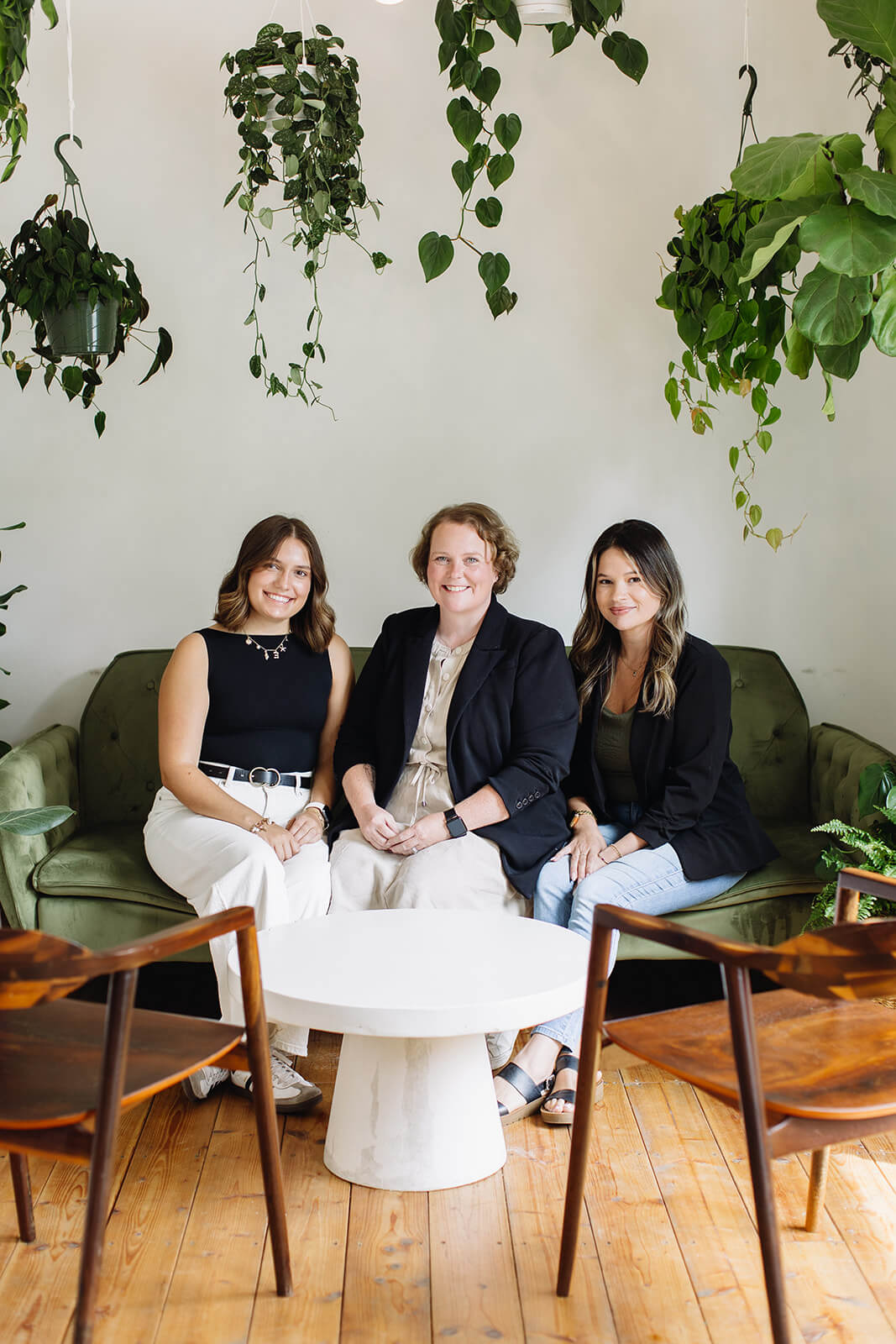 Three women sitting on green chair at Spruce in Jacksonville Fl