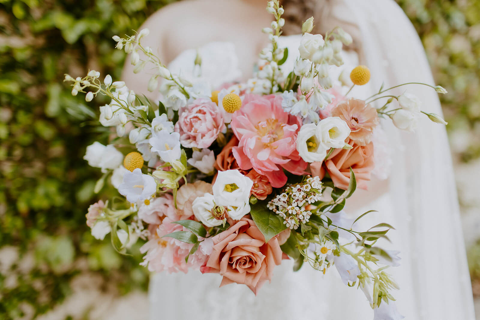 bride holding colorful floral arrangement on wedding day