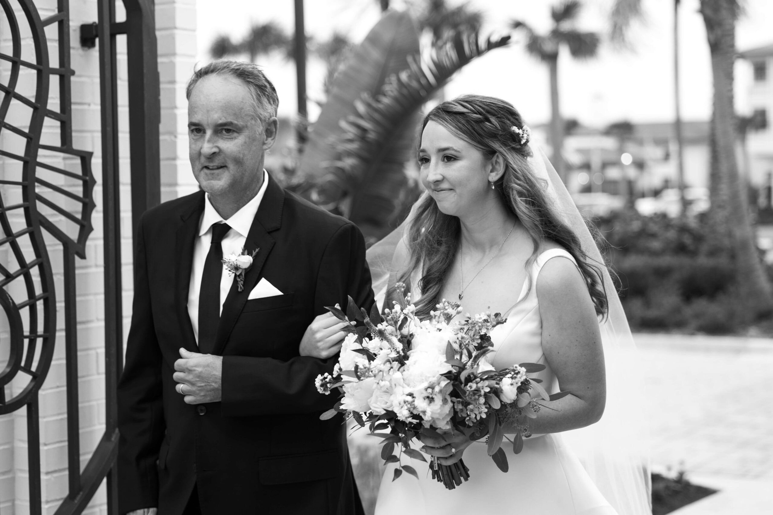 black and white image of bride and father walking down aisle