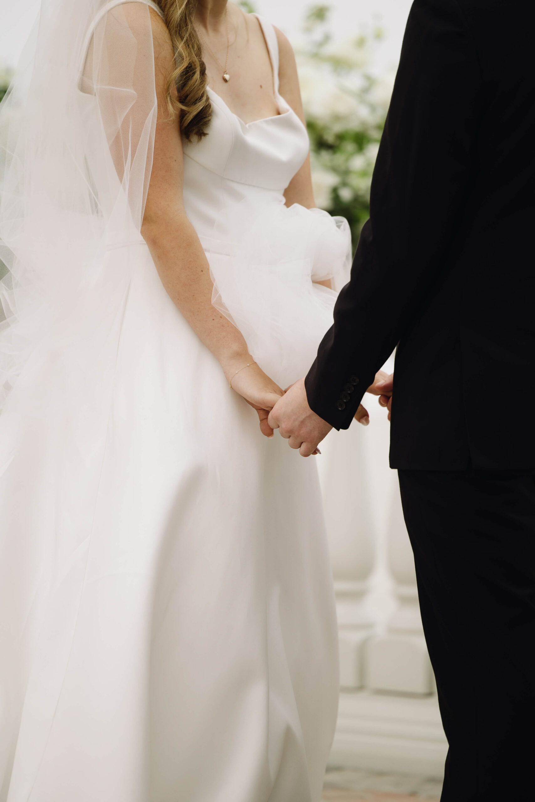 close up image of bride holding hands with groom