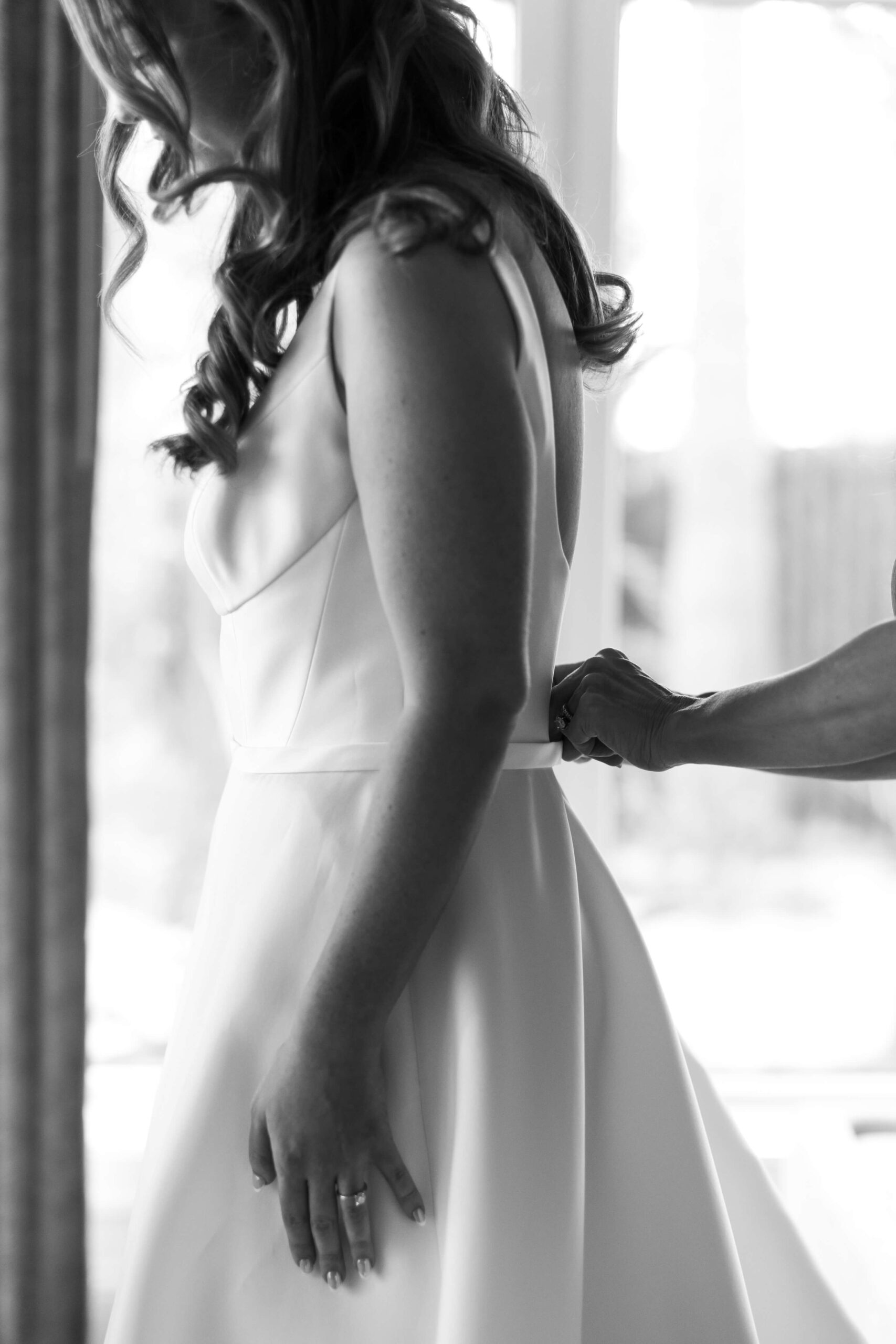 close up image of a bride getting her dress zipped up