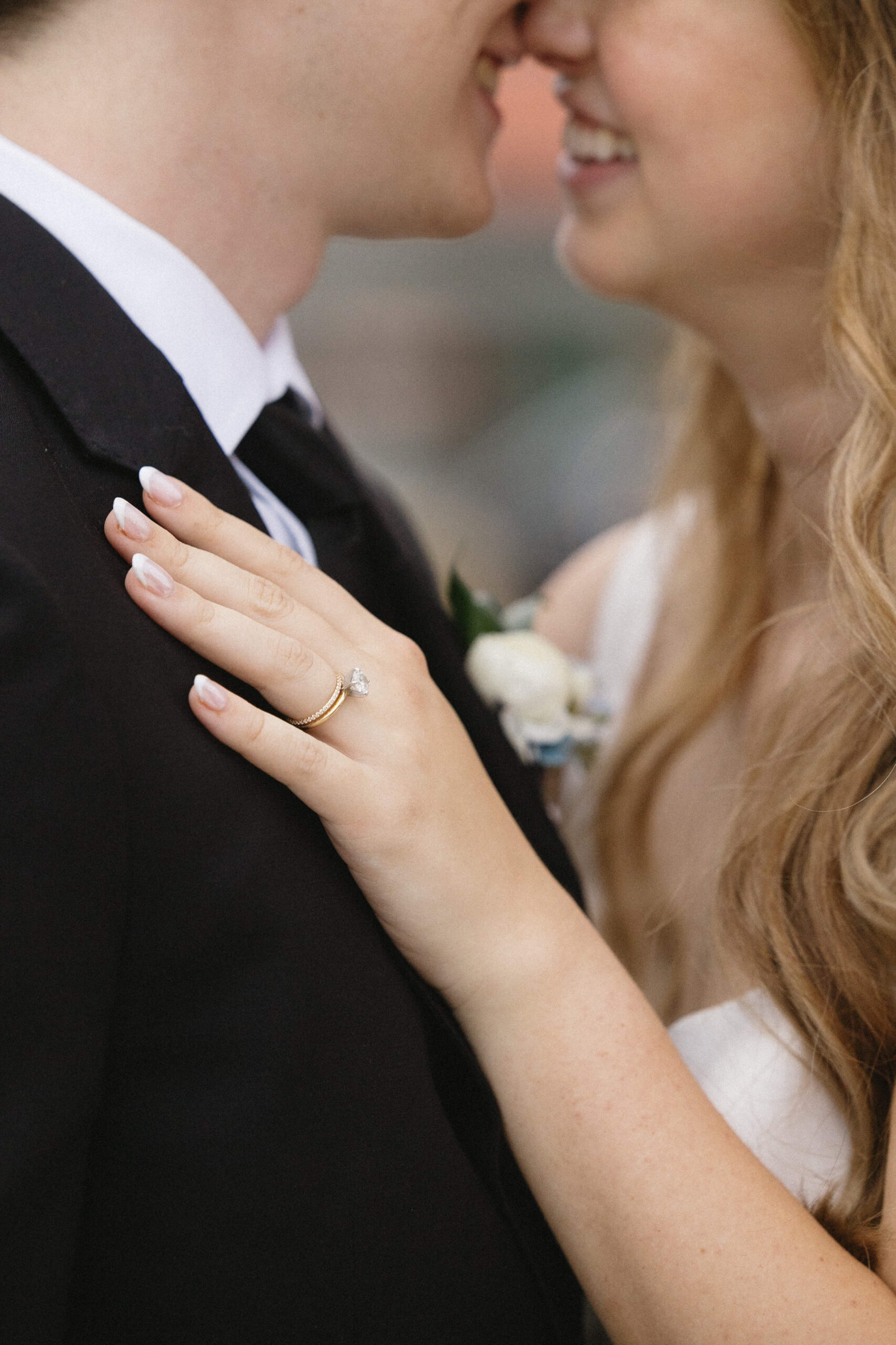 close up image of brides wedding ring on grooms chest