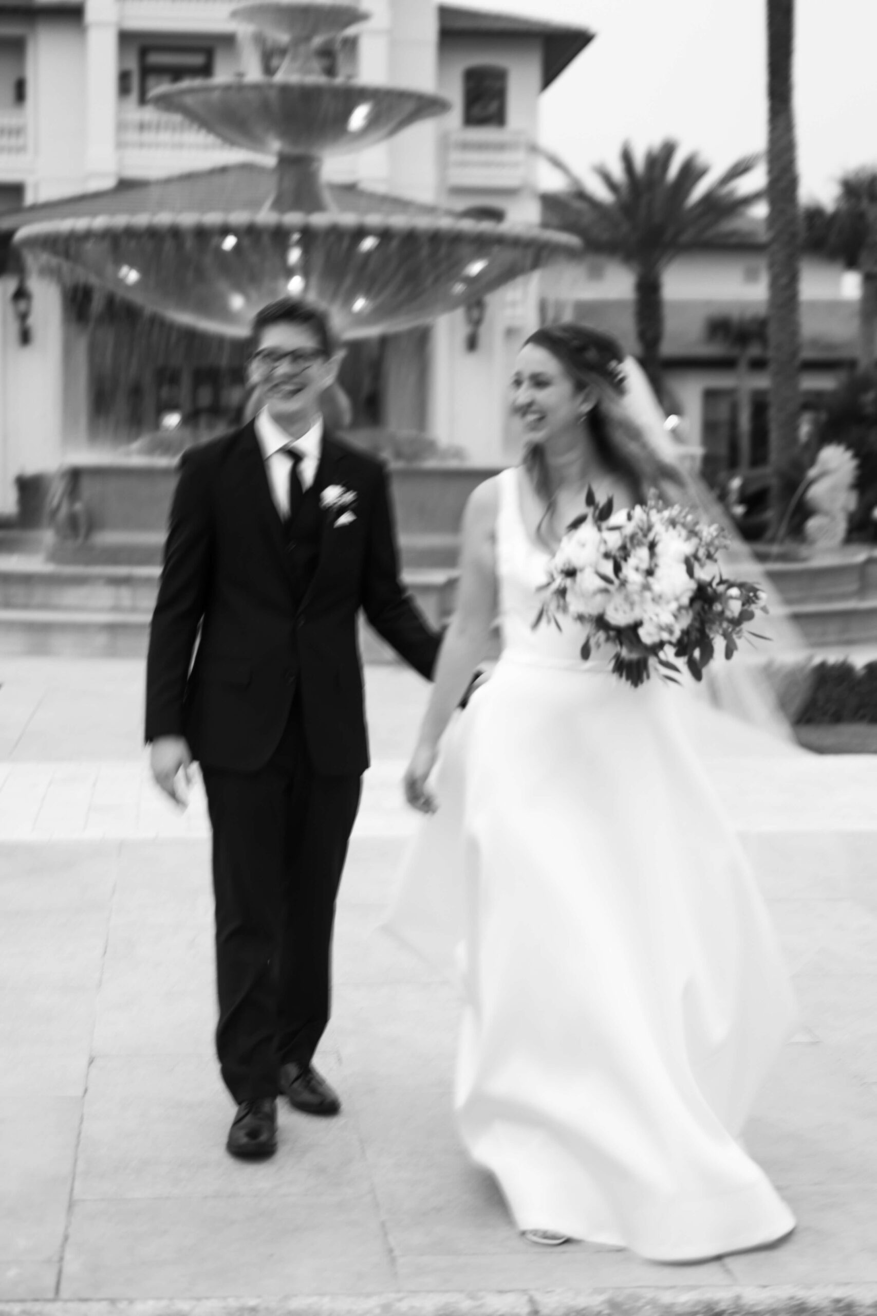 bride and groom walking together in front of ponte vedra inn and club fountain