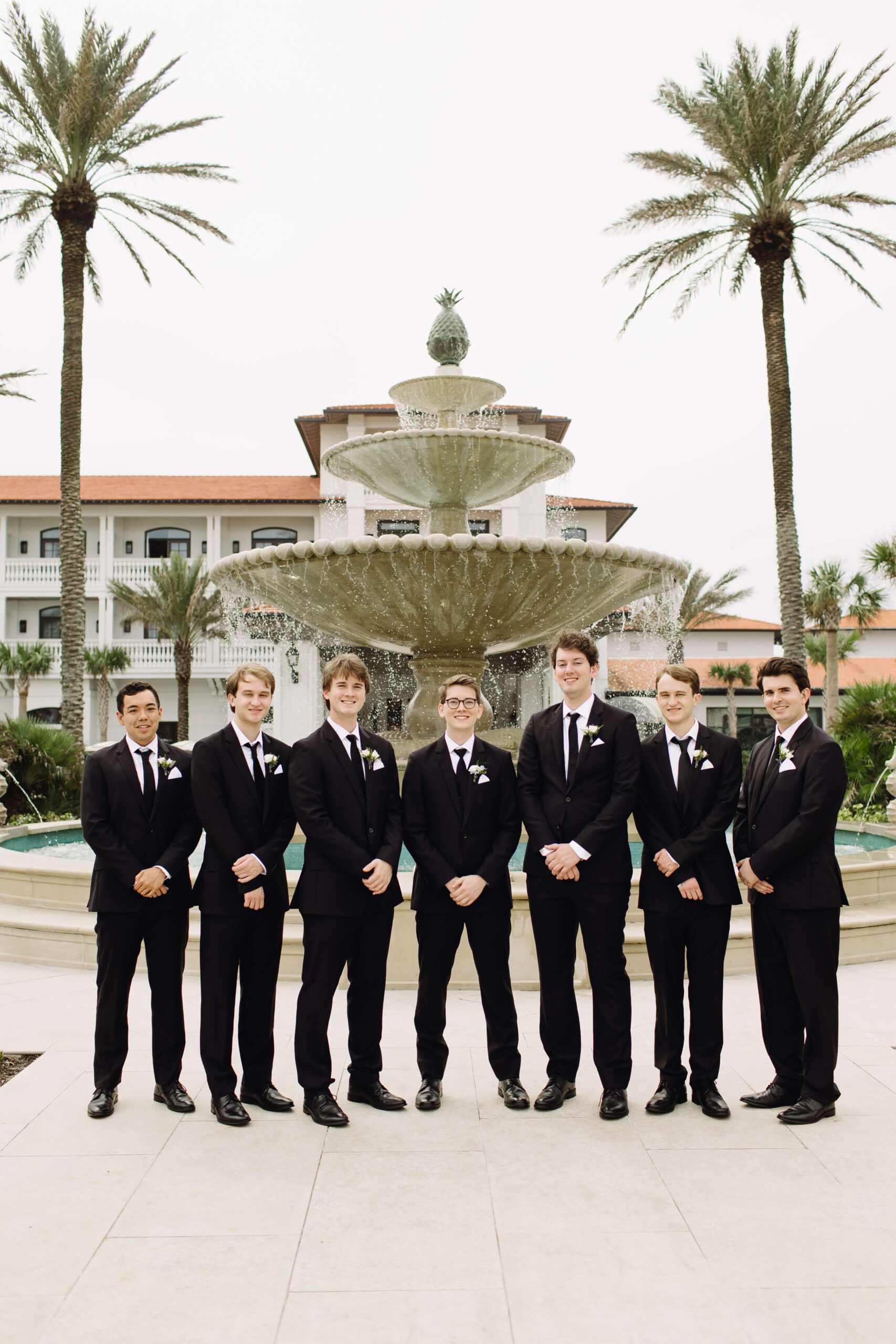 groom standing with groomsmen in front of fountain at ponte vedra inn and club