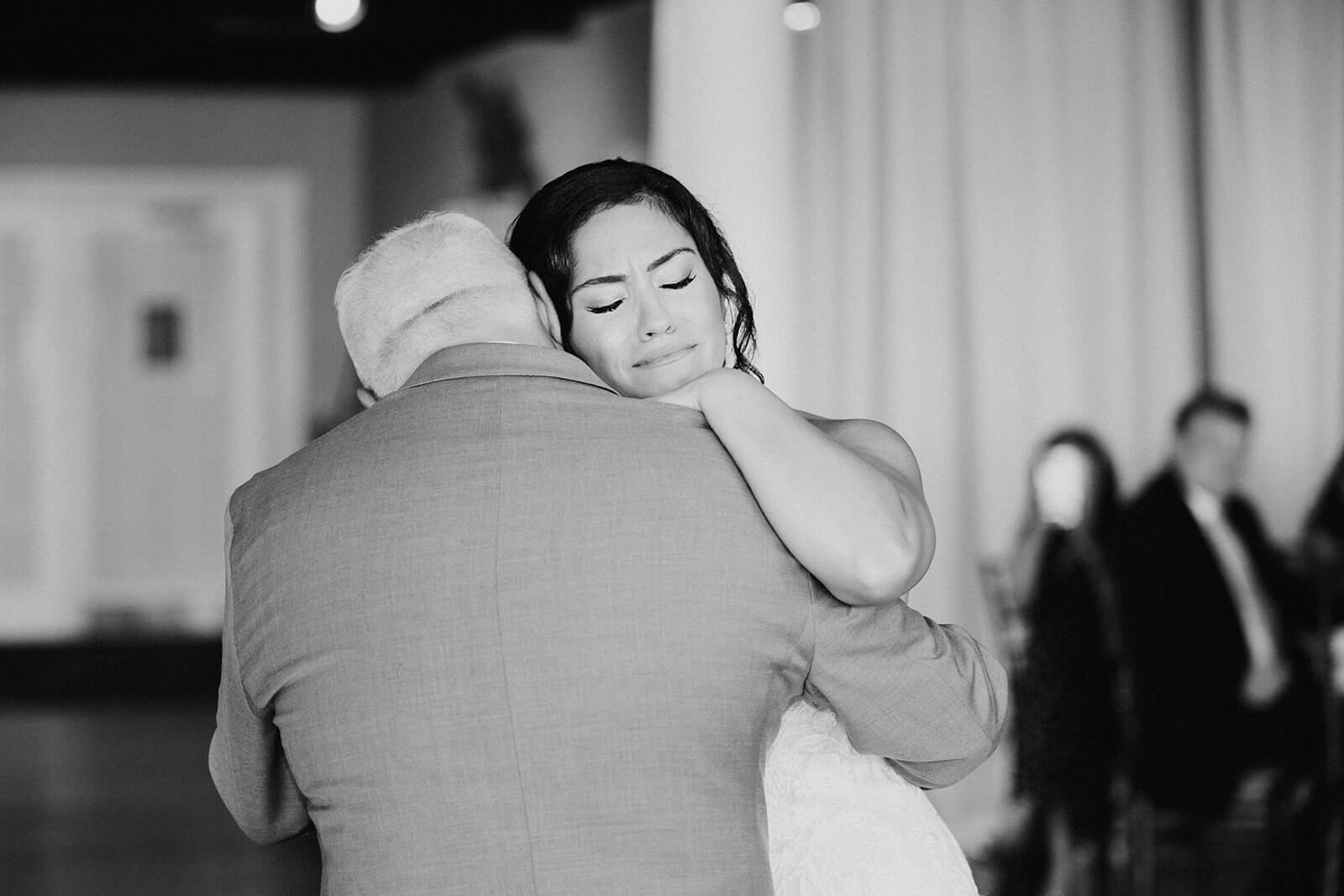 bride crying while dancing with father