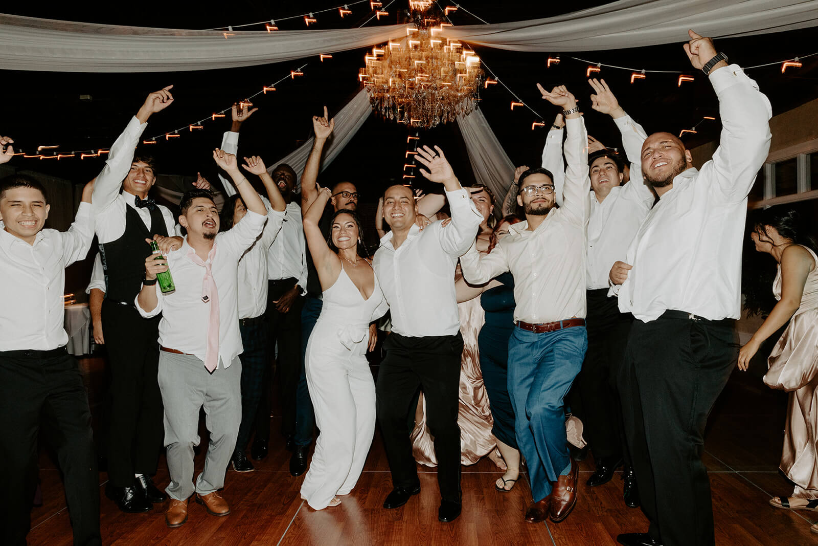 bride and groom dance with wedding guests at wedding reception