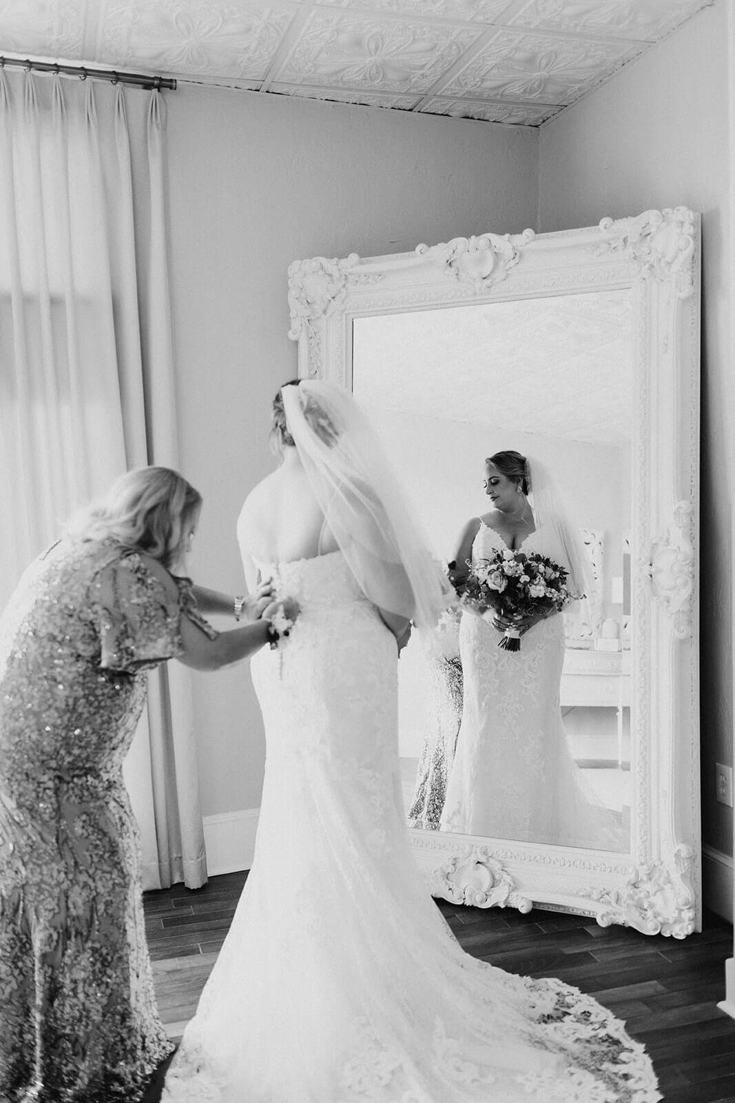 bride gets into her dress on wedding day