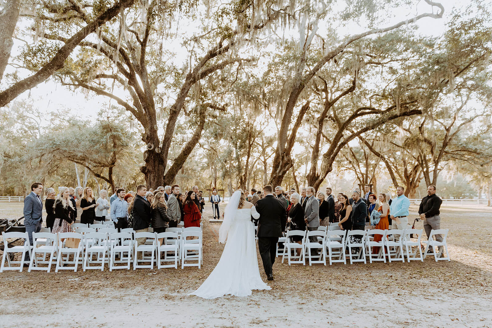 bride walking down aisle with her father, surrounded by wedding guests at chandler oaks farm wedding