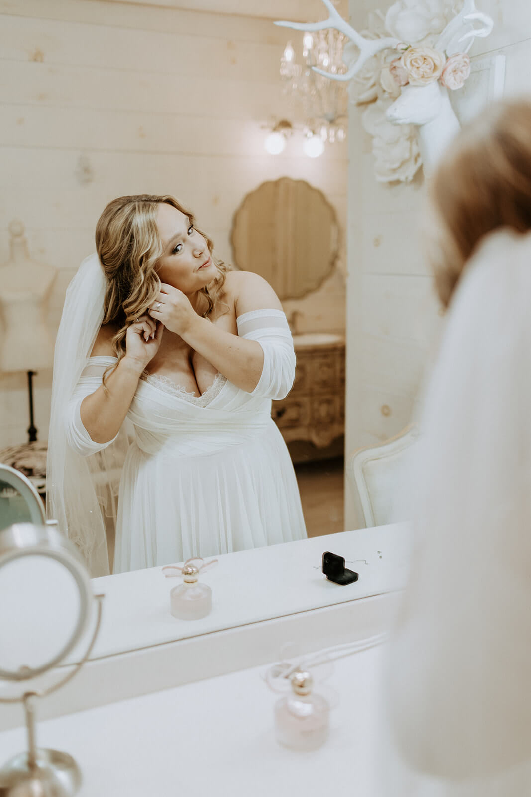 bride looking in the mirror in stunning wedding dress on wedding day