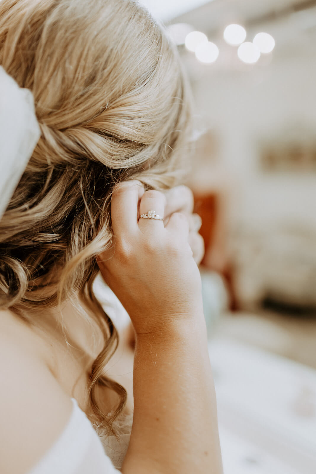 bride putting on earrings on wedding day