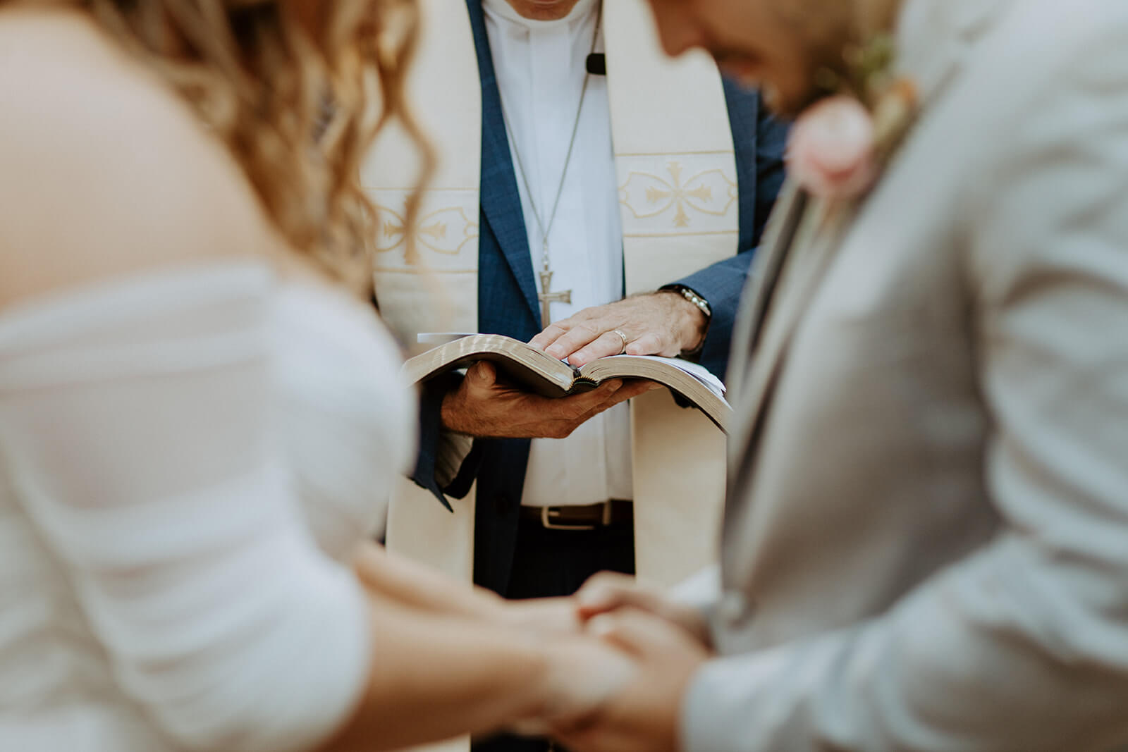 close up image of a bible in between a man and woman getting married