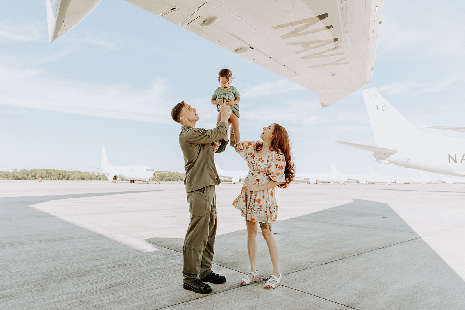 Man and women standing under p-8 wing