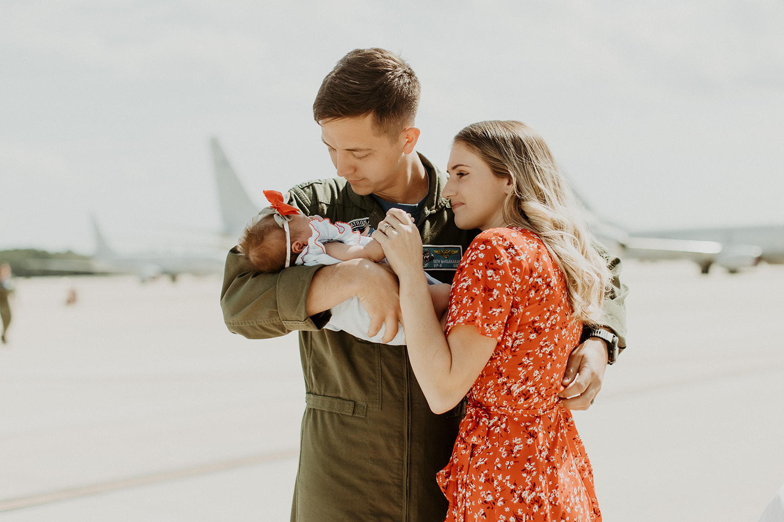 Man and woman embrace while holding baby