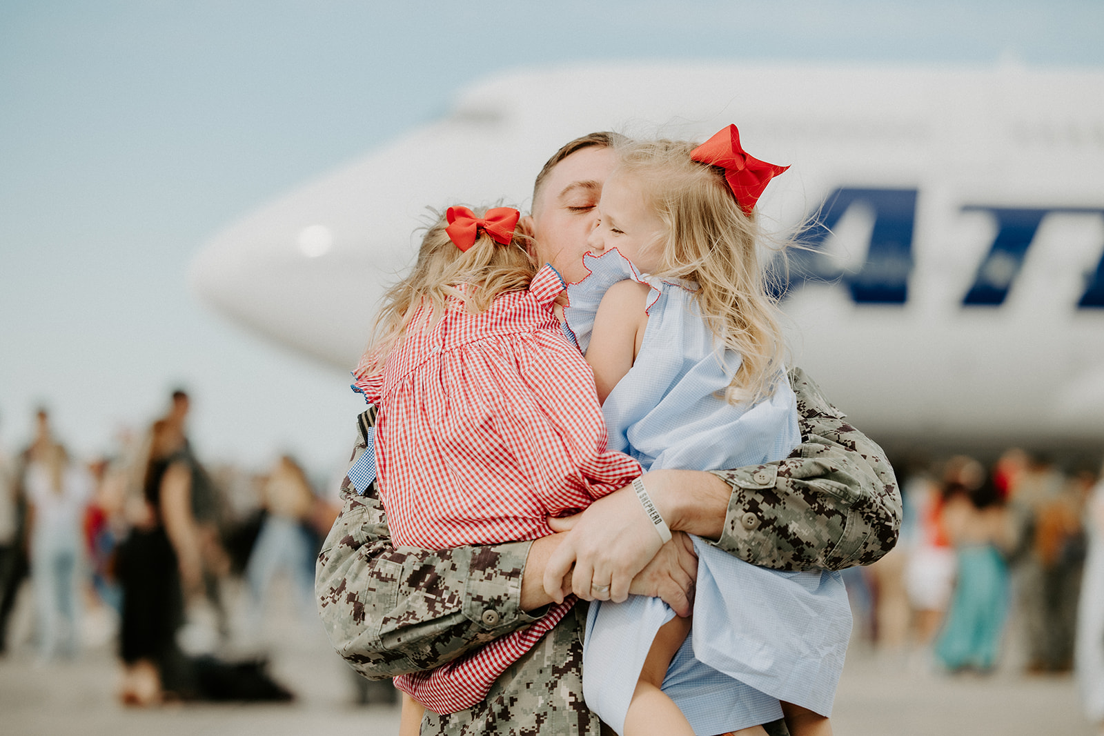 man hugging two daughters