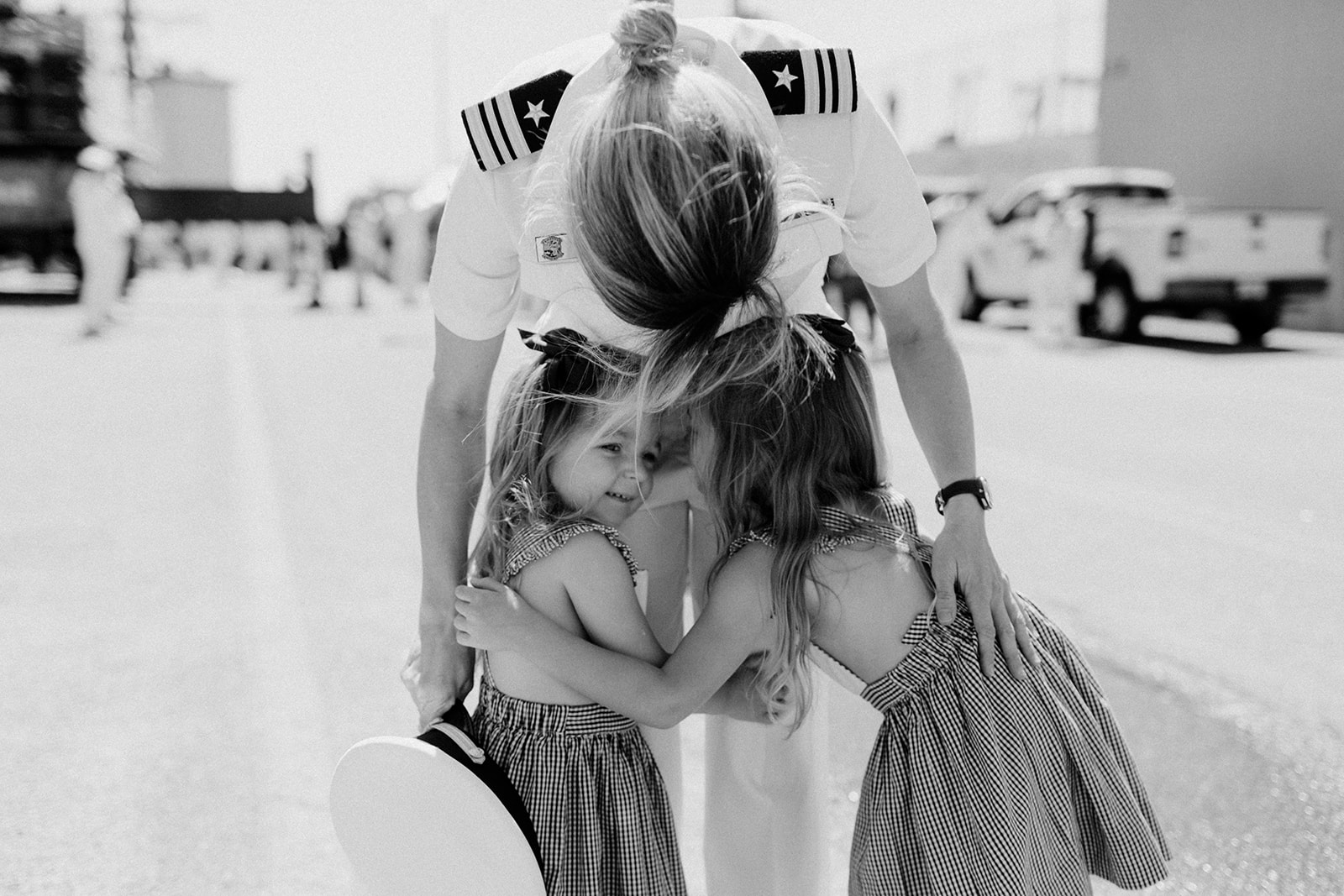 Navy woman hugging two children